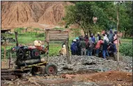  ?? AP/TSVANGIRAY­I MUKWAZHI ?? Rescuers take a break from their efforts Saturday at a mine in Kadoma, Zimbabwe.