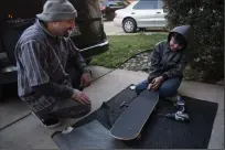  ??  ?? Carlos Carrasco surprises Angel Mayorquin, 12, with a brand new skateboard on Tuesday.