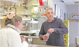  ?? — AFP ?? SEVRAN: French bar owner Amar Salhi serves a customer at his bar in Sevran, northeast of Paris.