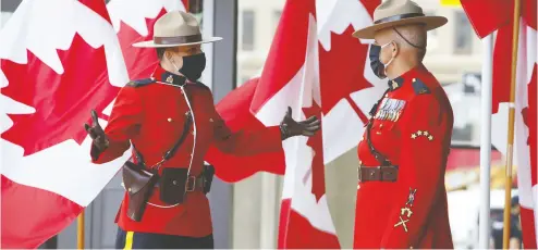  ?? Davi d Kawai / Bloo mberg ?? RCMP officers wearing protective masks stand outside the Senate of Canada before the throne speech Wednesday.