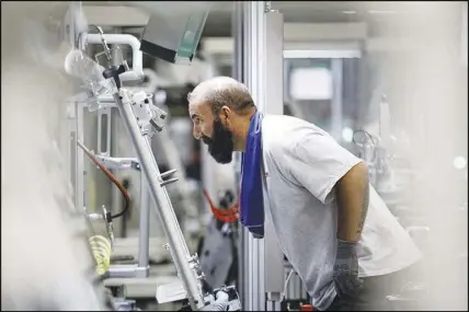  ??  ?? A worker inspects a product Tuesday at the Brose plant in Duncan, S.C., where the door systems for some BMWs are made. Brose, a German parts maker, also has plants in Michigan, Illinois and Alabama.