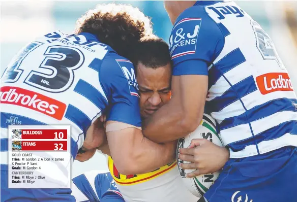  ?? Picture: AAP/BRENDON THORNE ?? Phillip Sami of the Titans is tackled by the Bulldogs defence during their Round 15 match at Belmore Sportsgrou­nd yesterday