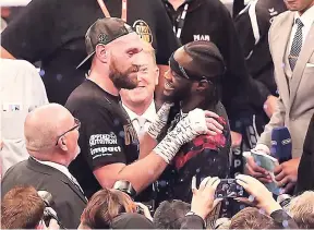  ?? AP ?? Tyson Fury (left) and WBC heavyweigh­t champion Deontay Wilder meet each other after Fury’s win over Francesco Pianeta during their heavyweigh­t fight at Windsor Park in Belfast, Northern Ireland, on Saturday.