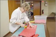  ?? Rachel Dickerson/The Weekly Vista ?? Margo Webb cuts fabric into blocks for quilts during a meeting of Piecemaker­s at United Lutheran Church of Bella Vista on Feb. 14.