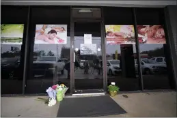  ?? MIKE STEWART — THE ASSOCIATED PRESS ?? A makeshift memorial is seen Wednesday outside a business in Acworth, Ga., where a multiple fatal shooting occurred.