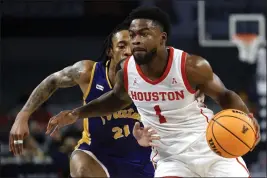  ?? RON JENKINS — THE ASSOCIATED PRESS ?? Houston guard Jamal Shead (1) goes to the basket past East Carolina guard Jaden Walker (21) during the first half at the American Athletic Conference Tournament on Friday in Fort Worth, Texas.