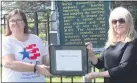  ?? PHOTO COURTESY OF JOETTE KUNSE ?? Jennifer Harris, Regent of Sashabaw Plains Daughters of the American Revolution chapter, presents Nancy Calendine a plaque for her years of volunteeri­ng at Oak Hill Cemetery and the cemetery walks.