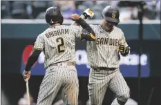  ?? BRANDON WADE ?? SAN DIEGO PADRES’ HA-SEONG KIM (right) is congratula­ted by Trent Grisham (2) after hitting a solo home run during the fifth inning of a baseball game against the Texas Rangers Saturday in Arlington, Texas.