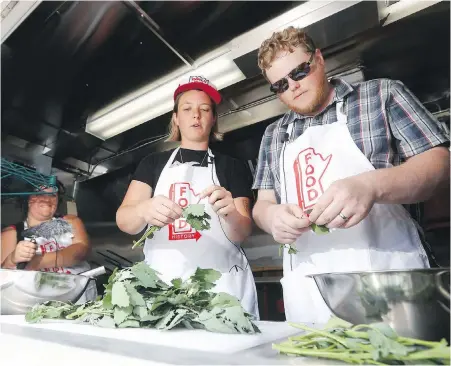  ?? PHOTOS BY THE CANADIAN PRESS ?? Sarah Story and Kent Davies, from the Manitoba Food History Project, interview Anna Sigrithur, centre, producer of the Ox Tales podcast, as she cooks up crepes inside the project’s food truck at the Mennonite Heritage Village in Steinbach, Man.