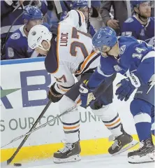  ?? AP PHOTO ?? TWO FOR ONE: Oilers winger Milan Lucic and Tampa Bay Lightning winger Chris Kunitz fight for the puck during last night’s game.