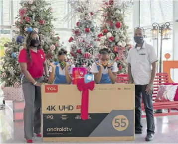  ??  ?? From left; Digicel Brand Marketing Manager Reshima Kelly joins Edwin Allen star athletes Tina and Tia Clayton, and team Head Coach Michael Dyke for a festive holiday-themed handover at the Digicel Ocean Boulevard headquarte­rs.