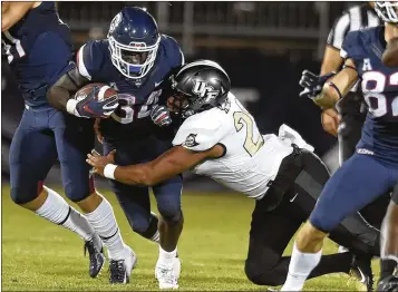  ?? BRAD HORRIGAN / HARTFORD COURANT ?? Connecticu­t running back Kevin Mensah carries the ball against UCF at Rentschler Field in East Hartford, Conn., on Thursday. The Knights racked up 652 yards of offense in a 56-17 victory.