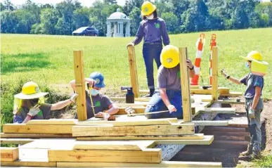  ?? STAFF PHOTO BY ROBIN RUDD ?? From left, Southeast Conservati­on Corps team members Juliana Williams, Emily Mathis, Autumn Beeland, Ruth Beeland and Gracie Fogo build a footbridge across a stream in McDonald Field, just south of the Chickamaug­a and Chattanoog­a National Military Park’s Visitor Center.