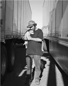  ??  ?? Comer, a truck driver from North Carolina, poses for a portrait with his dog Dontea by his truck at the Flying J truck stop in Laredo, Texas on Apr 5.