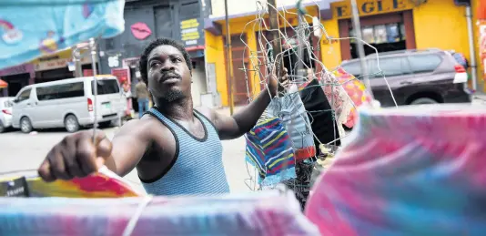  ?? GLADSTONE TAYLOR/MULTIMEDIA PHOTO EDITOR ?? Clothes vendor Jeremiah Bryan, who operates on Orange Street in downtown Kingston, says that relaxing the COVID-19 curfew for the Christmas season is not worth the risk.