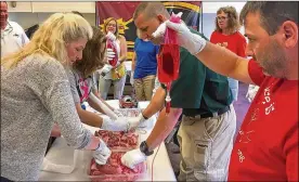  ??  ?? Ross Schools teachers and administra­tors thrust medical gauze into holes in beef as part of their first training in emergency casualty care. The new training in the Butler County school system will help school staffers stop bleeding from gaping wounds...