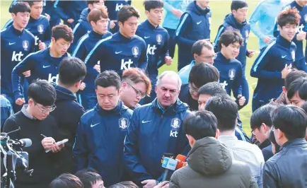  ?? Yonhp ?? Korean national football team coach Uli Stielike, center, is interviewe­d during the team’s training at the National Training Center in Paju, north of Seoul, Friday. The football team returned home after taking a 0-1 loss to China at the Asian...