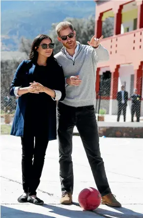  ?? AP AP ?? Prince Harry and Meghan, Duchess of Sussex, watch children playing football at a school in the town of Asni, in the Atlas mountains of Morocco.