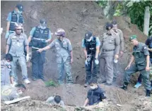  ?? — Reuters ?? Thai police and workers recover the bodies of a British citizen Alan Hogg and his Thai wife Nod Suddaen buried near a creek on their property in the province of Phrae.