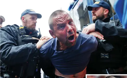  ??  ?? Seized: One of Robinson’s disciples is held by police outside Old Bailey yesterday
