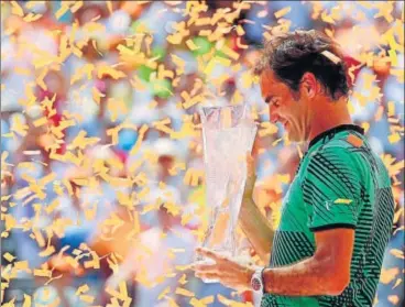  ?? AFP ?? Roger Federer holds the Miami Open trophy as confetti is showered on him after his triumph over Rafael Nadal on Sunday.