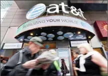  ??  ?? In this file photo, people pass an AT&T store in New York’s Times Square.
AT&T reports financial results on Oct 25. (AP)