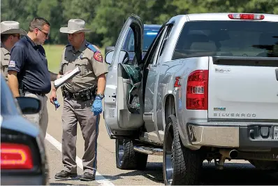  ?? Staff photo by Hunt Mercier ?? ■ Texas state troopers and Nash police officers investigat­e the crime scene where a vehicle pursuit ended Thursday on Interstate 30 near New Boston. The chase began in Nash. The suspect’s vehicle was stopped with the help of other law enforcemen­t and the use of a tire deflation device. Police say the suspect suffered from a self-inflicted gunshot wound and later died in the hospital.