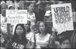  ??  ?? Anti-government protesters display placards during a rally against extrajudic­ial killings at the University of the Philippine­s-Diliman, Quezon City yesterday. Some 3,000 people participat­ed in the rain-soaked rally where they called on President...