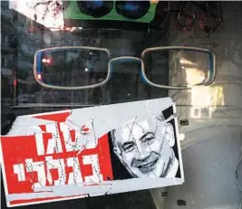  ?? ARIEL SCHALIT/AP ?? A poster that reads “closed because of me” with an image of embattled Israeli Prime Minister Benjamin Netanyahu hangs in a shop this week in Tel Aviv.