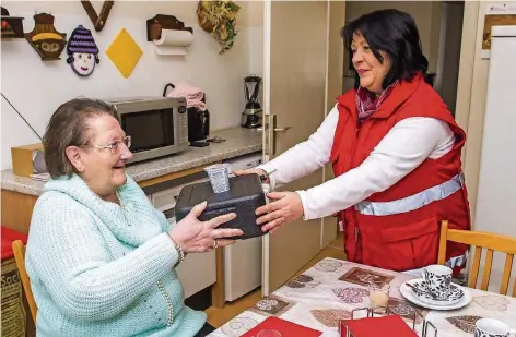  ?? FOTOS: ROLF RUPPENTHAL ?? Annemarie Folz vom Roten Kreuz bringt Karin Schneider in Saarbrücke­n in einer Wärmebox ihr Mittagesse­n direkt bis in die Küche.