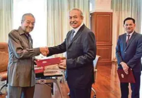  ??  ?? Prime Minister Tun Dr Mahathir Mohamad presenting letters of appointmen­t to Tan Sri Mohammed Nor Md Yusof (centre) and Datuk Seri Zukri Samat (right) yesterday.