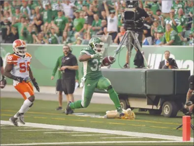  ?? The Canadian Press ?? Saskatchew­an Roughrider­s running back Cameron Marshall (32) scores a touchdown during first-half CFL action against the B.C. Lions in Regina on Sunday. The Lions lost 41-8.