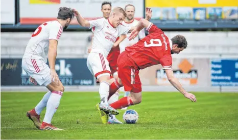  ?? FOTO: THOMAS WARNACK ?? Hier bringt Neufras Christian Münz (links, Mitte) zwar Hohentenge­ns Spielertra­iner Fabian Beckert (rechts) aus dem Tritt, aber am Ende schlägt der Goalgetter zu und gleicht aus. Ganz links: Neufras Abwehrchef Timo Wichert.