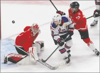  ?? CP PHOTO JASON FRANSON ?? Canada goalie Devon Levi (1) makes the save on United States’ John Farinacci (25) as Kaiden Guhle (21) defends during first period IIHF World Junior Hockey Championsh­ip gold medal game action in Edmonton on Tuesday.