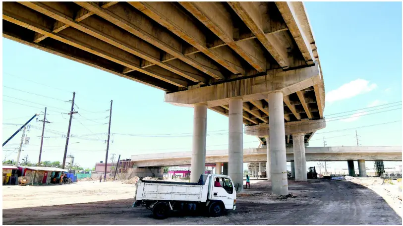  ??  ?? A motorist drives a small truck under a section of the new Three Miles interchang­e, which should be completed by December 2019.