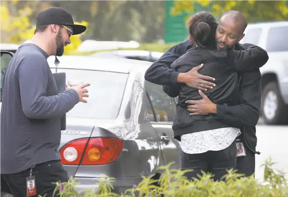  ?? Photos by Paul Chinn / The Chronicle ?? Unidentifi­ed YouTube employees hug outside of the company’s headquarte­rs buildings as they return to the campus following the shooting attack on Tuesday.