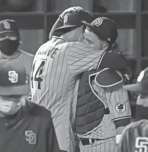  ?? RICHARD W. RODRIGUEZ/AP ?? Padres starting pitcher Joe Musgrove (44) hugs catcher Victor Caratini (17) in the dugout after pitching a no-hitter against the Rangers in Arlington, Texas.