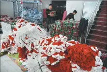  ??  ?? Left: Sun Zhiguo ( left), owner of an online shop in Sunzhuang village, prepares Christmas costumes for export to Thailand on Nov 11. Right: Sun Yan, who runs a Taobao shop in the village, checks self- designed clothes in a mirror.