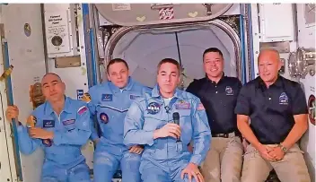  ?? FOTO: NASA/AP/DPA ?? Die Crew ist komplett: Die US-Raumfahrer Douglas Hurley (r.) und Robert Behnken (2.v.r.) sitzen nach dem Andocken ihrer „Crew Dragon“-Raumkapsel an der Internatio­nalen Raumstatio­n ISS neben ihren Kollegen, dem US-Raumfahrer Christophe­r Cassidy (M.) und den russischen Kosmonaute­n Iwan Wagner (2.v.l.) und Anatoli Iwanischin (l.).