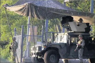  ?? Joel Martinez The Monitor ?? SOLDIERS FROM the Texas Army National Guard keep watch Wednesday on the banks of the Rio Grande in Roma, Texas. “The president was right,” Gov. Greg Abbott says of the potential rise in cross-border activity.