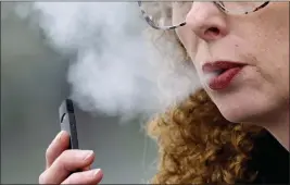  ?? CRAIG MITCHELLDY­ER — THE ASSOCIATED PRESS FILE ?? A woman exhales while vaping from a Juul pen e-cigarette in Vancouver, Wash.