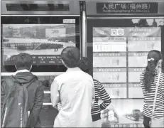  ??  ?? BEIJING
People watch military parade on a screen.
-REUTERS