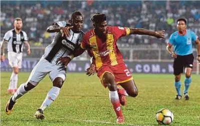  ?? BERNAMA PIC ?? Terengganu’s Kipre Tchetche (left) and Selangor’s M. Manimaran vie for the ball in a Super League match at the Sultan Ismail Nasiruddin Shah Stadium yesterday.