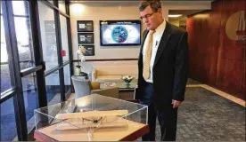  ?? THOMAS GNAU / STAFF ?? Tim Lawrence, senior VP and general manager of MacAulay-Brown, examines a model of a Wright Flyer at the company’s Beavercree­k offices.