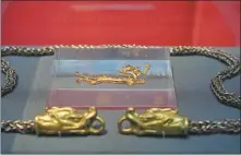  ?? PHOTOS BY GAO ERQIANG / CHINA DAILY ?? From left: Gold dragon and the silver chain with gilded bronze dragon heads, both being among the Tang Dynasty (618-907) collection of the Xi’an Museum. Visitors appreciate a coral dragon of the modern period, part of the collection of the Shanghai Museum, at The Longing for Spring: A Celebratio­n of the Year of the Dragon exhibition.