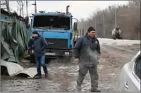  ?? (AFP) ?? Workers walk near a destroyed truck in Kyiv on Thursday.