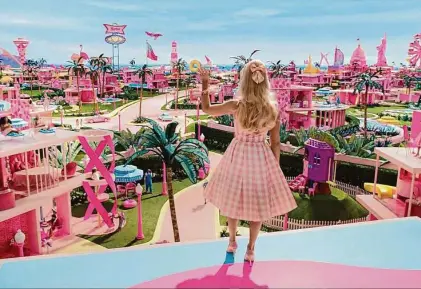  ?? Courtesy of Warner Bros. Pictures/TNS ?? Barbie (Margot Robbie) looks upon Barbieland in “Barbie,” a film that looks at bimboism through pink-colored glasses.