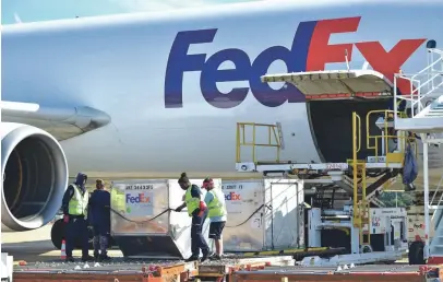  ??  ?? FedEx material handlers offload containers at the Memphis hub on Friday, Oct. 12. FedEx expects to add more than 55,000 positions throughout its network to help the holidays arrive this year, with 3,800 positions in Memphis. FedEx Express is hiring for 1,000 positions, and FedEx Ground is hiring for 2,800 positions. These include permanent, part-time, seasonal package handlers and other support positions. STAN CARROLL / THE COMMERCIAL APPEAL