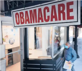  ?? JOE RAEDLE/GETTY 2021 ?? A person walks to the office of a Miami insurance agent offering plans under the Affordable Care Act.