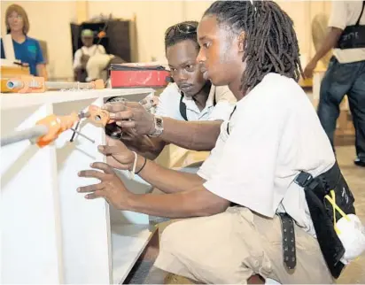  ?? COURTESY ?? Two Step-Up Apprentice­ship Initiative students work inside the cabinetry shop. The programs offers men and women over 18 a job while they gain employable skills and build a resume.